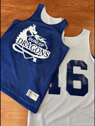 Photo of team jerseys with school logo on front and large number on back.